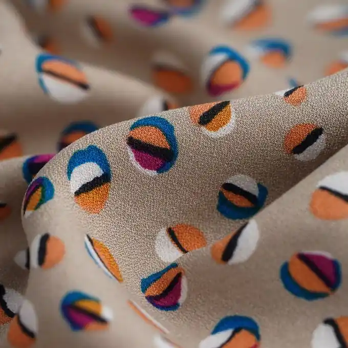 Billig Stoff aus beigefarbener Viskosekrepp mit bunten Blasenmuster