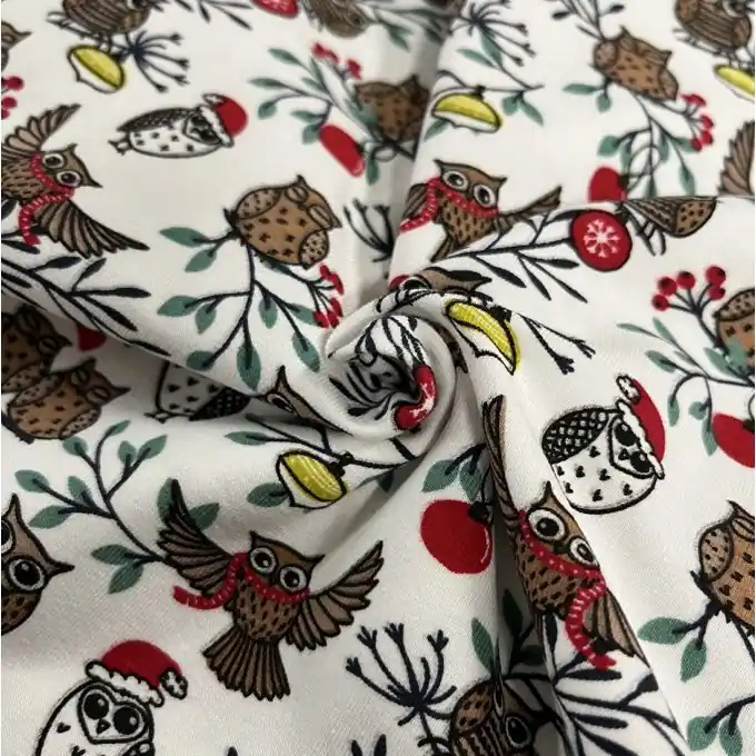 Weihnachtsstoff aus Baumwolljersey mit Eulenmotiv in Weiß. Großhandel